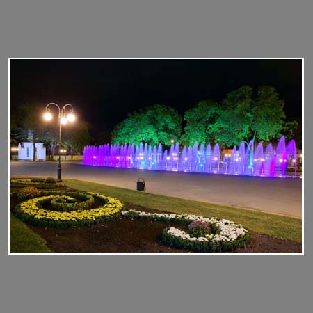 Цветник и цветомузыкальный фонтан при искусственном освещении.